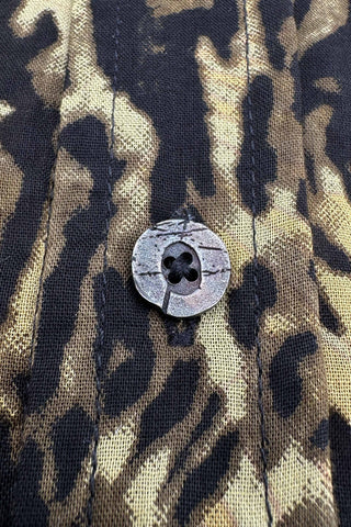 Close-up of a button on a fabric with a camouflage pattern