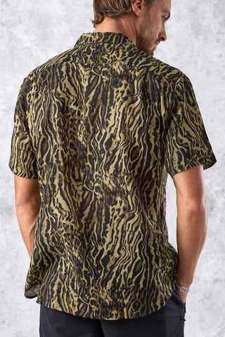 Man wearing a patterned shirt against a textured white background